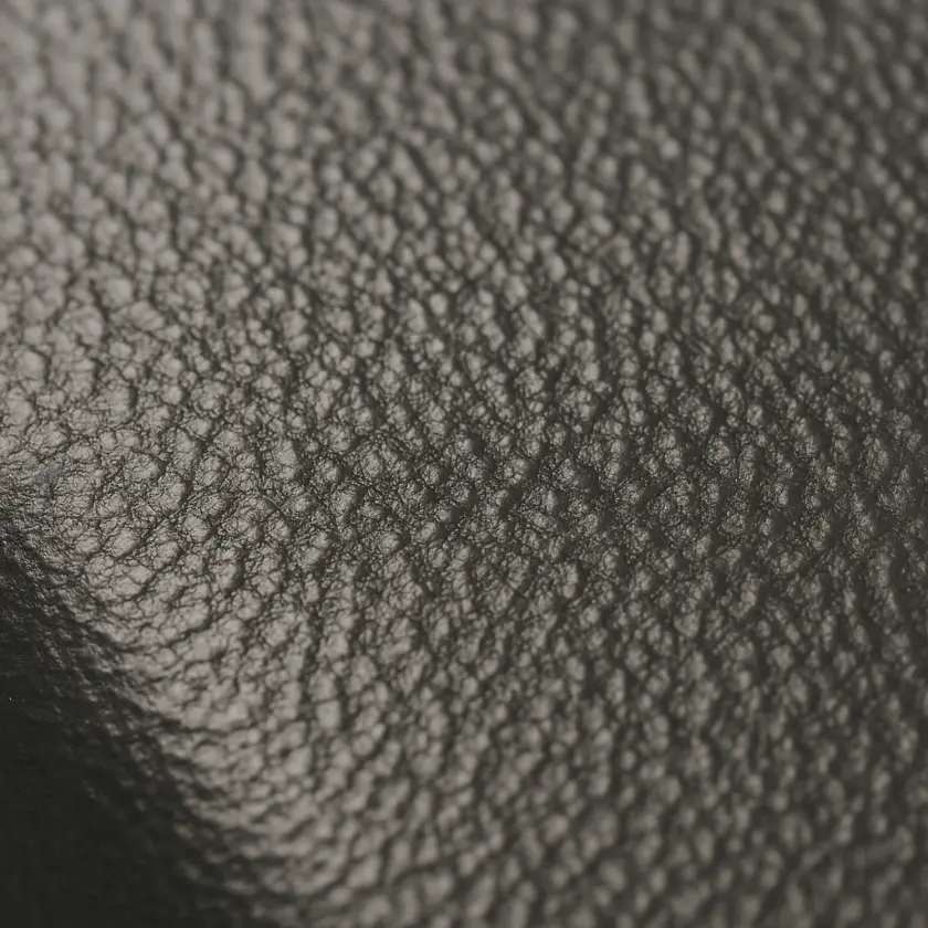 Macro photograph showing a crinkled textured metal surface coated with powder, demonstrating a finish that showcases both design flexibility and potential disadvantages of powder coating like surface variation.